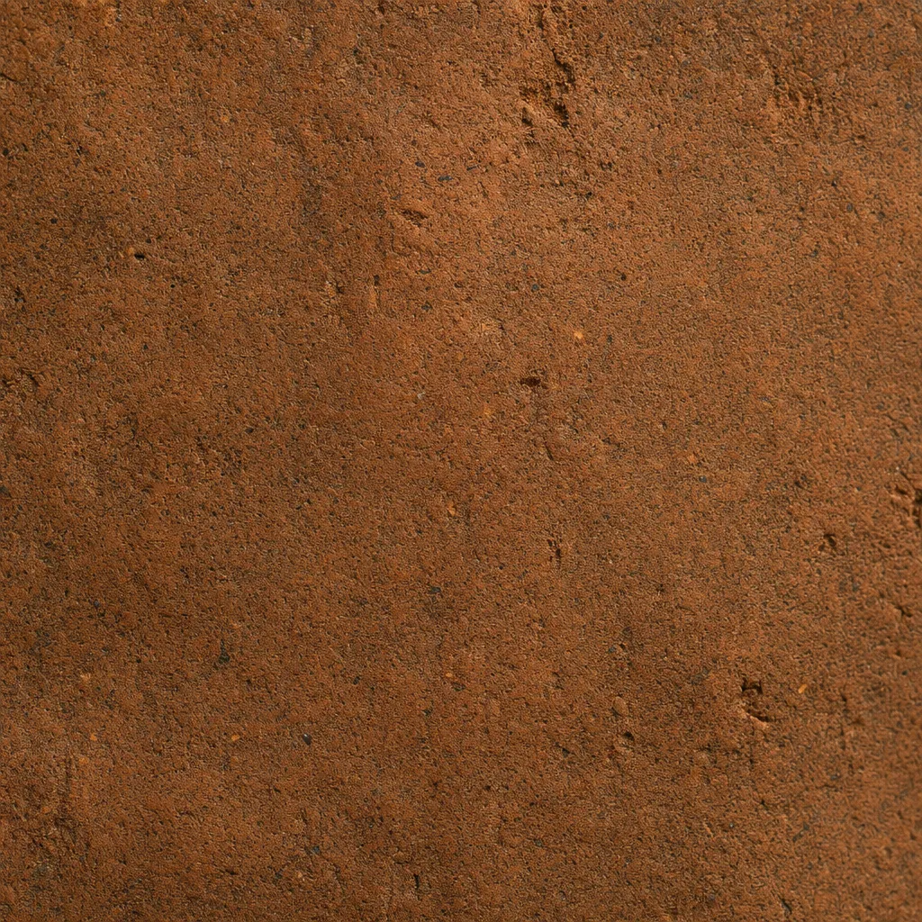 Representative visualization of a reddish-brown fired-clay amulet surface with fine granular texture.